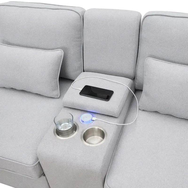 Canapé rembourré avec console, deux porte-gobelets et deux ports USB prenant en charge la recharge filaire ou sans fil ; style minimaliste moderne.